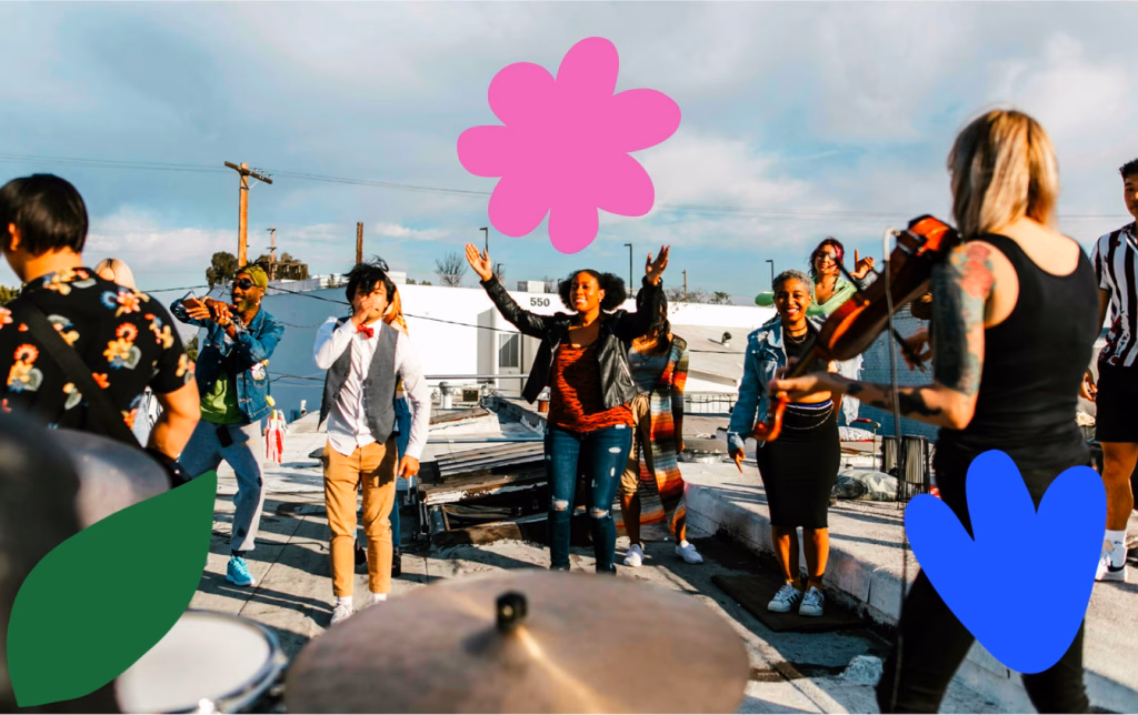 A diverse group of people celebrating on a rooftop, dancing and singing together while a violinist performs on the right side.
